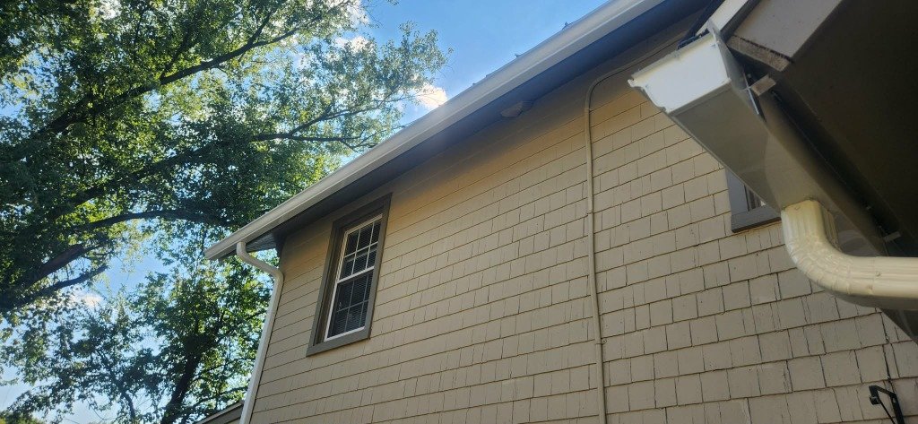 New white gutter install on beige shingle home