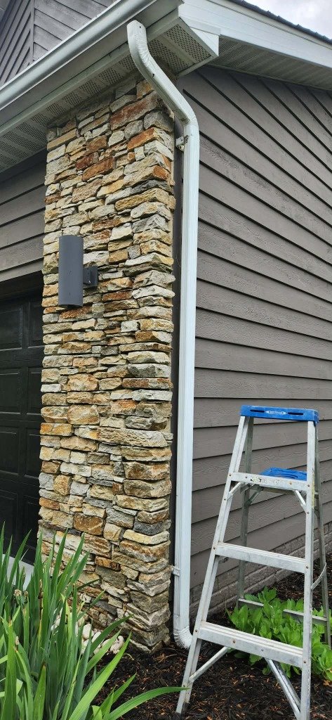 Downspout installation on stone facade Baltimore